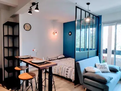 a bedroom with a bed and a table and a chair at Charmant studio, cœur de ville in Narbonne