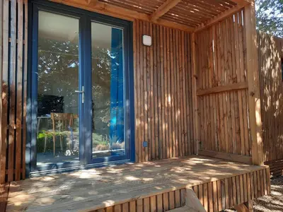a screened porch of a house with a window at Le lodge des chênes in Brousses-et-Villaret