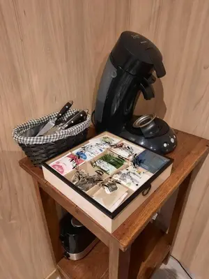 a table with a coffee maker and a book on it at Le lodge des chênes in Brousses-et-Villaret