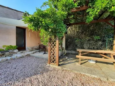 a picnic table and a tree in front of a house at Le lodge des chênes in Brousses-et-Villaret