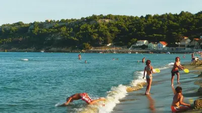 a group of people playing in the water at the beach at Résidence du Portail d'Avail in Sigean