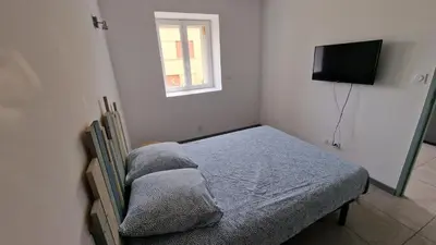 a small bedroom with a bed and a window at Résidence du Portail d'Avail in Sigean