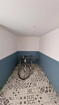 a bike parked in a room with a tile floor at Résidence du Portail d'Avail in Sigean