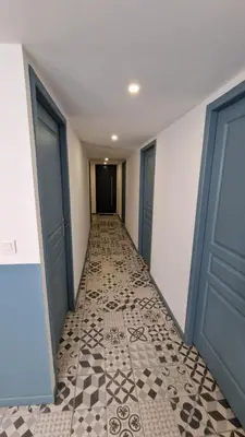 an empty hallway with two doors and a tile floor at Résidence du Portail d'Avail in Sigean