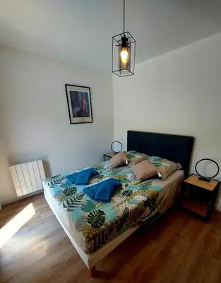 a bedroom with a bed and a pendant light at La Belle Vie en Alaric in Douzens