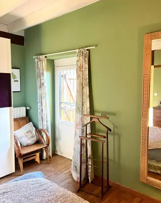 a bedroom with green walls and a window at Symphony du Vivant in Lautrec