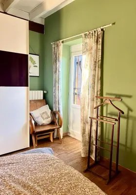 a bedroom with green walls and a bed and a window at Symphony du Vivant in Lautrec