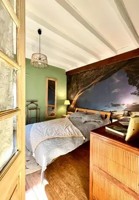 a bedroom with a bed and a large painting on the wall at Symphony du Vivant in Lautrec