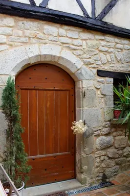 a wooden door on the side of a stone building at Symphony du Vivant in Lautrec