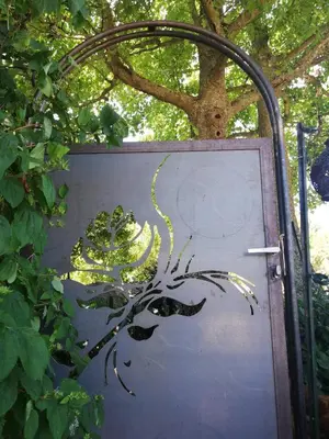 a metal door with a plant painted on it at Symphony du Vivant in Lautrec