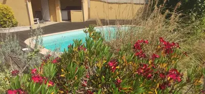 a garden with flowers in front of a swimming pool at Adorable guest house with piscine and spa in Lempaut