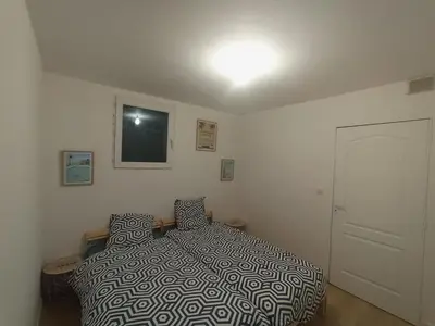 a bedroom with a bed with a black and white comforter at Adorable guest house with piscine and spa in Lempaut