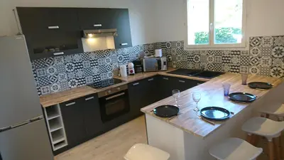 a kitchen with black cabinets and a wooden counter top at Adorable guest house with piscine and spa in Lempaut