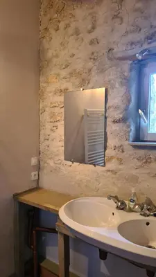 a bathroom with a sink and a mirror at Gîte du caveau in Marcorignan