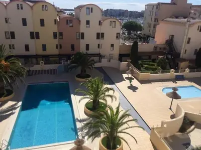 an apartment with a swimming pool on a building at Bellyenmer Gruissan in Gruissan