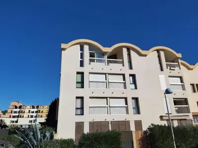 a white building with balconies on the side of it at Bellyenmer Gruissan in Gruissan