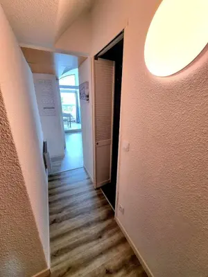 a hallway with an open door to a room with wood floors at Bellyenmer Gruissan in Gruissan