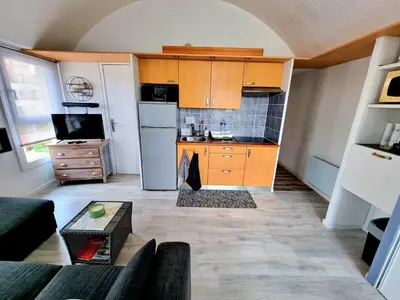 a living room with a kitchen with a couch and a table at Bellyenmer Gruissan in Gruissan