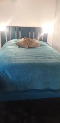 a bed with a blue comforter and a pillow at Maison Occitane in Saint-Nazaire-dʼAude
