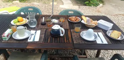 a wooden table with breakfast food on it at Maison Occitane in Saint-Nazaire-dʼAude