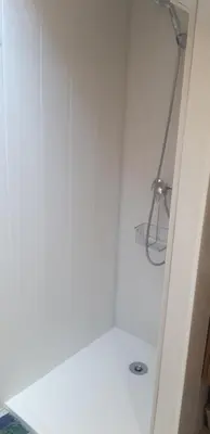 a shower in a bathroom with a white wall at Maison Occitane in Saint-Nazaire-dʼAude