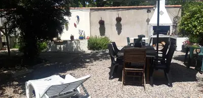 a group of chairs and a table in a yard at Maison Occitane in Saint-Nazaire-dʼAude