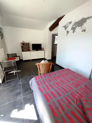a bedroom with a bed and a world map on the wall at Studio R Homps in Homps