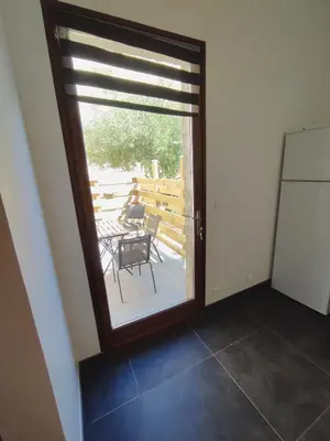 a door leading to a patio with a table and chairs at Studio R Homps in Homps