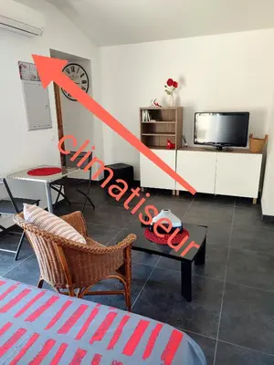 a living room with a table and a tv at Studio R Homps in Homps