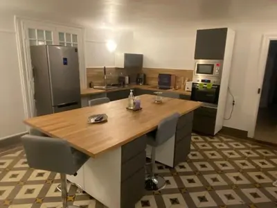 a kitchen with a wooden table and a refrigerator at Domaine de ferrabouc in Mas-Saintes-Puelles