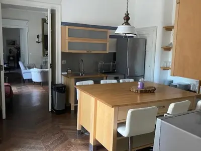 a kitchen with a large wooden table and white chairs at Domaine de ferrabouc in Mas-Saintes-Puelles