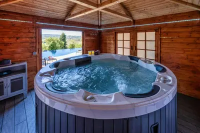 a large hot tub in a room with a tv at Domaine de ferrabouc in Mas-Saintes-Puelles