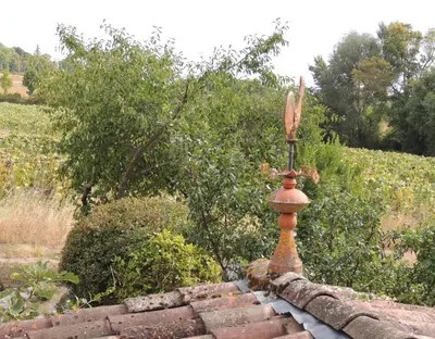 a brick wall with a statue on top of it at Les treilles d'en Peyre in Nogaret