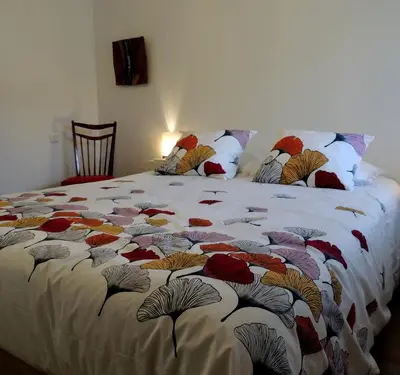 a bed with a colorful blanket on top of it at Les treilles d'en Peyre in Nogaret