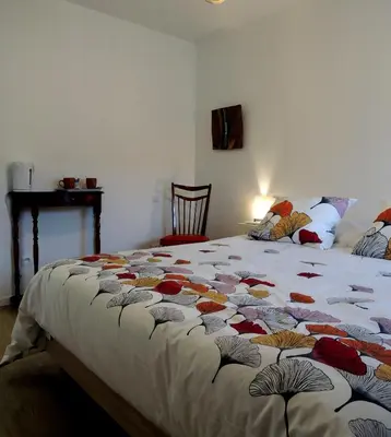a bedroom with a bed with a quilt on it at Les treilles d'en Peyre in Nogaret