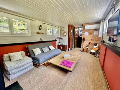 a bedroom with a bed and a couch and a table at Péniche Dondon - Gîte cocooning sur Canal du midi in Avignonet-de-Lauragais