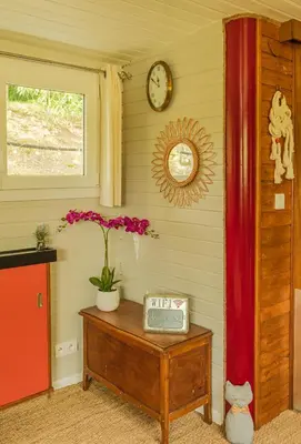 a room with a table with a clock on the wall at Péniche Dondon - Gîte cocooning sur Canal du midi in Avignonet-de-Lauragais