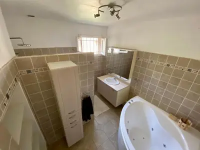 a bathroom with a tub and a toilet and a sink at Belle et grande villa pour des séjours en famille et entre amis in Cruscades