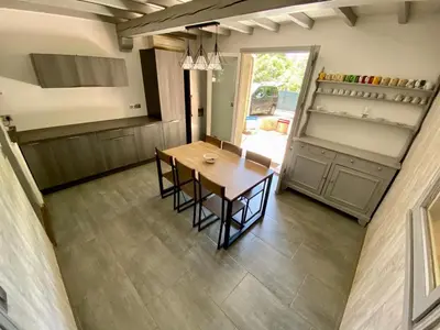 a kitchen with a table and chairs in a room at Belle et grande villa pour des séjours en famille et entre amis in Cruscades