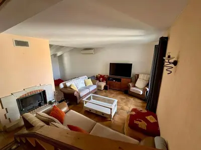 a living room with a couch and a fireplace at Belle et grande villa pour des séjours en famille et entre amis in Cruscades