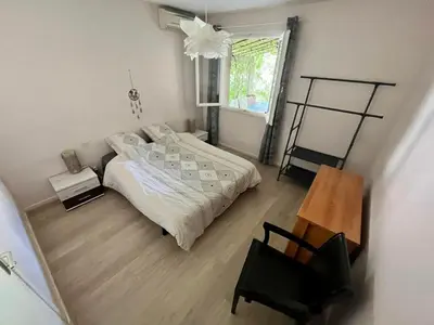 a bedroom with a bed and a chair and a window at Belle et grande villa pour des séjours en famille et entre amis in Cruscades