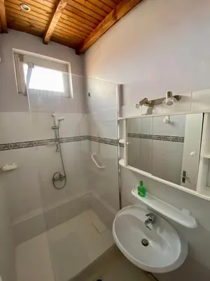 a white bathroom with a sink and a shower at Belle et grande villa pour des séjours en famille et entre amis in Cruscades