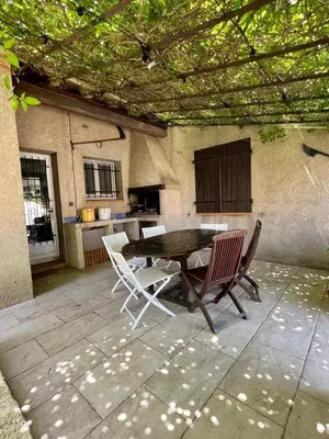 a patio with a table and chairs and a kitchen at Belle et grande villa pour des séjours en famille et entre amis in Cruscades