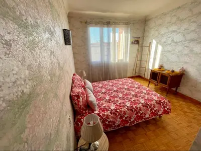 a bedroom with a red bed and a wall at Très grand appartement à 10 min à pied du centre in Castres