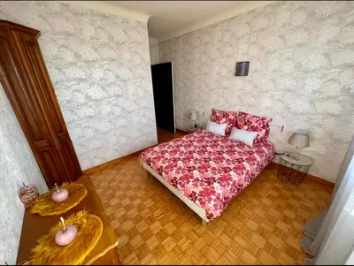 a bedroom with a bed with a red blanket at Très grand appartement à 10 min à pied du centre in Castres