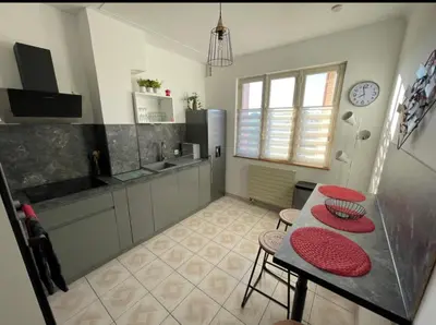 a kitchen with a table and some chairs and a counter at Très grand appartement à 10 min à pied du centre in Castres