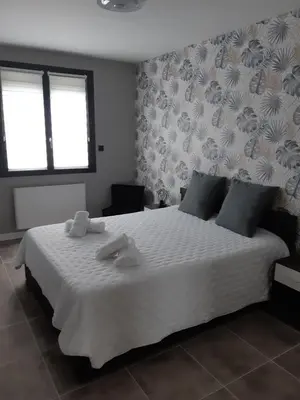 a bedroom with a large white bed with towels on it at Appartement fonctionnel proche du centre ville in Narbonne