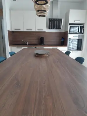 a kitchen with a wooden table in a room at Appartement fonctionnel proche du centre ville in Narbonne