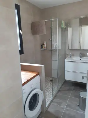 a bathroom with a washing machine and a shower at Appartement fonctionnel proche du centre ville in Narbonne