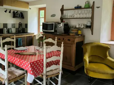 a kitchen with a table with a red and white table cloth at Gite du grand cèdre in CampÃ´me